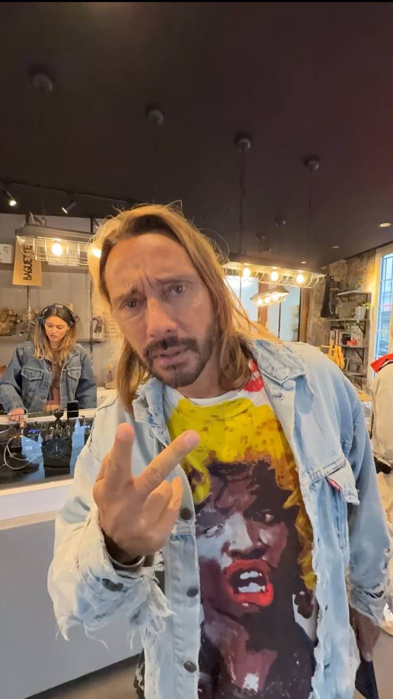 Le DJ dans la boutique, une DJ en veste en jean aux platines derrière lui.