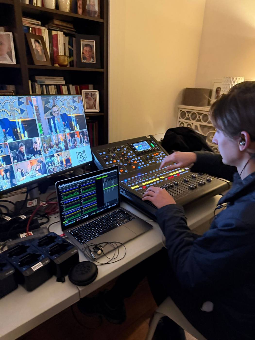 Ingénieur du son à la console de mixage, écran multi-vue et ordinateur portable.