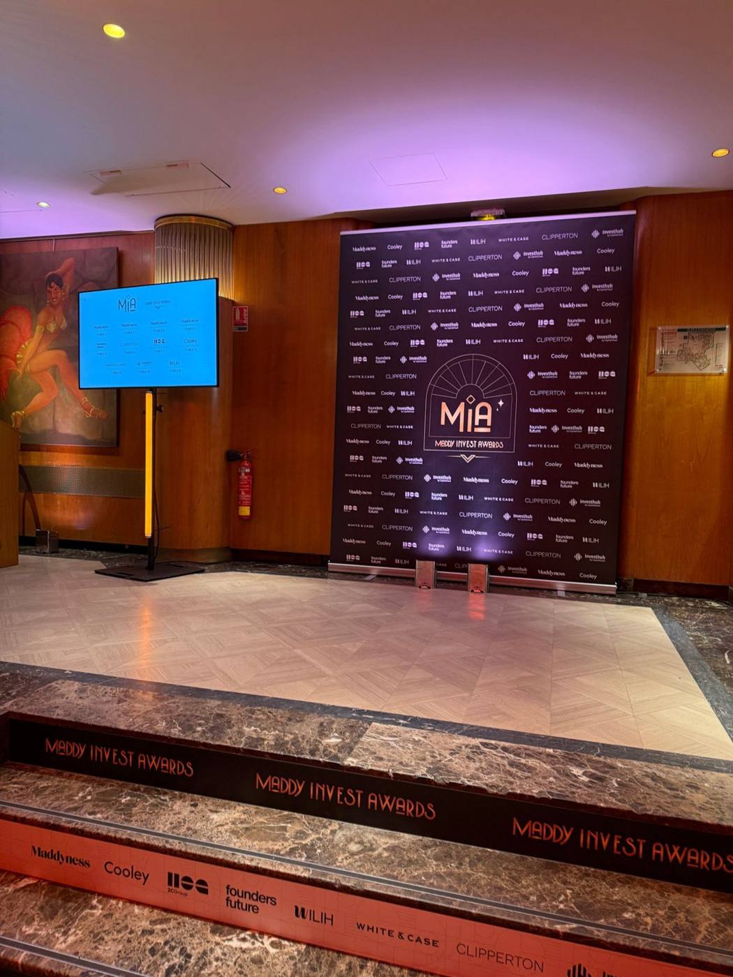 Photocall Maddy Invest Awards aux logos des partenaires, écran d'accueil et marches habillées.
