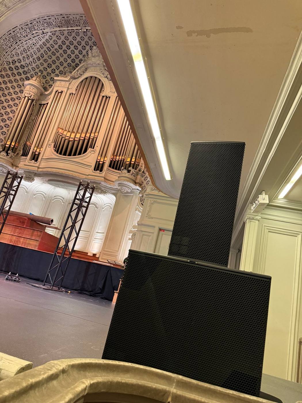 Enceintes de façade face à l'orgue de la salle, structures de scène en arrière-plan.