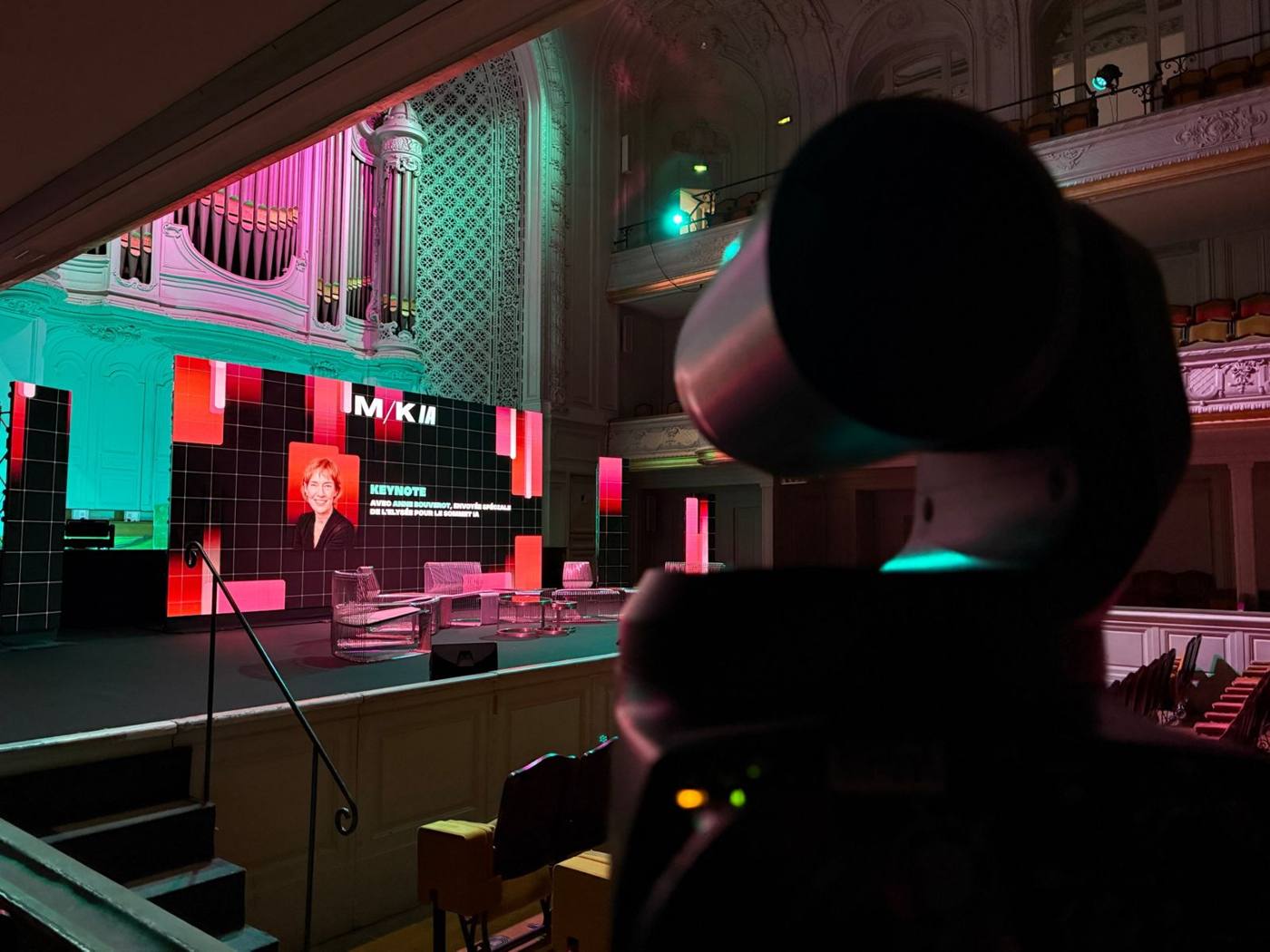 Caméra motorisée au premier plan, scène avec mur LED annonçant une keynote.