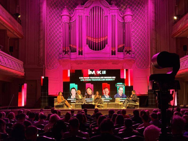 Table ronde sur scène devant l'orgue de la salle, écran M/K IA au-dessus des intervenants, public de dos.