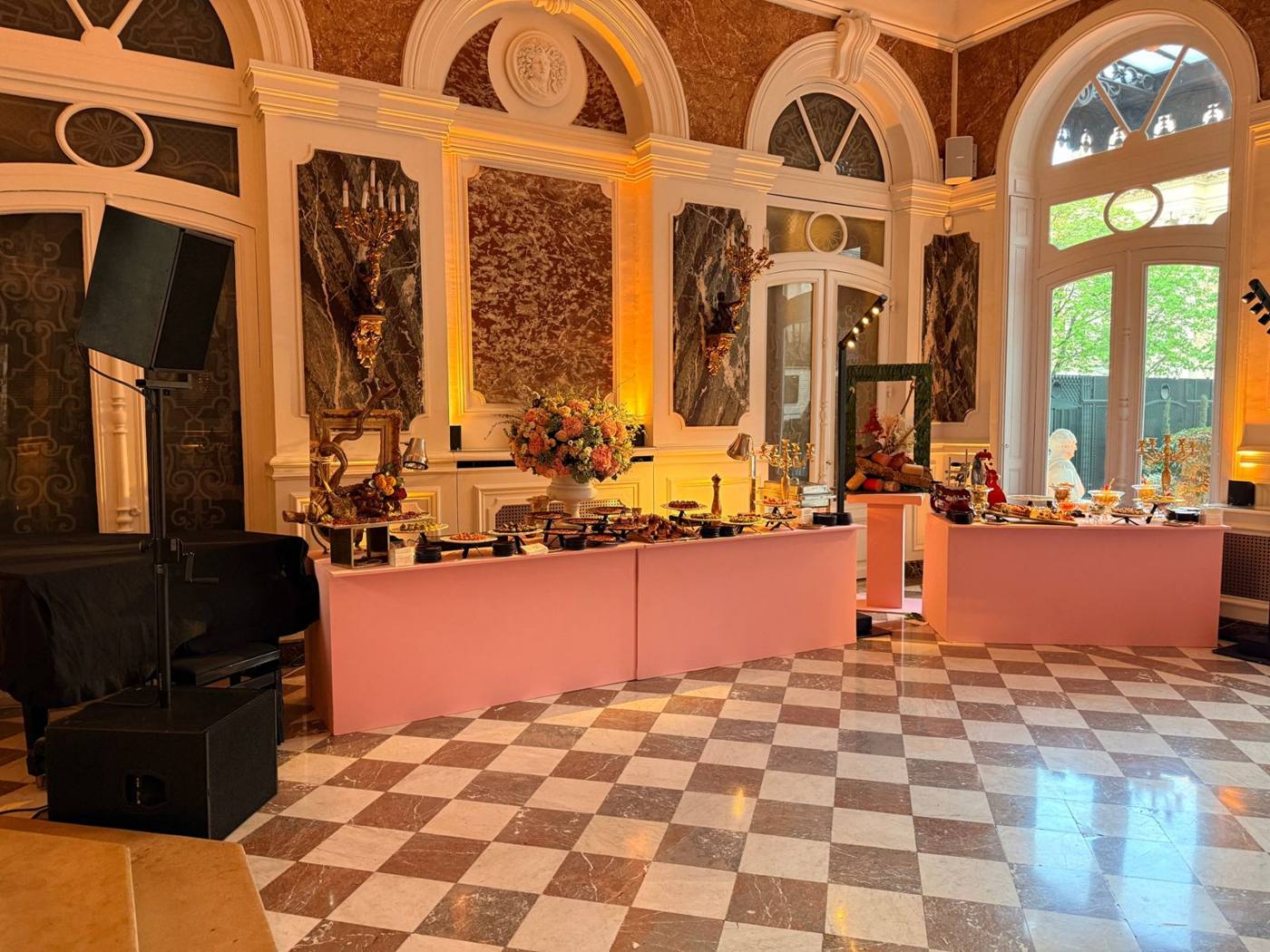 Salon de marbre à damier avec buffets roses, enceinte sur pied et caisson de grave.
