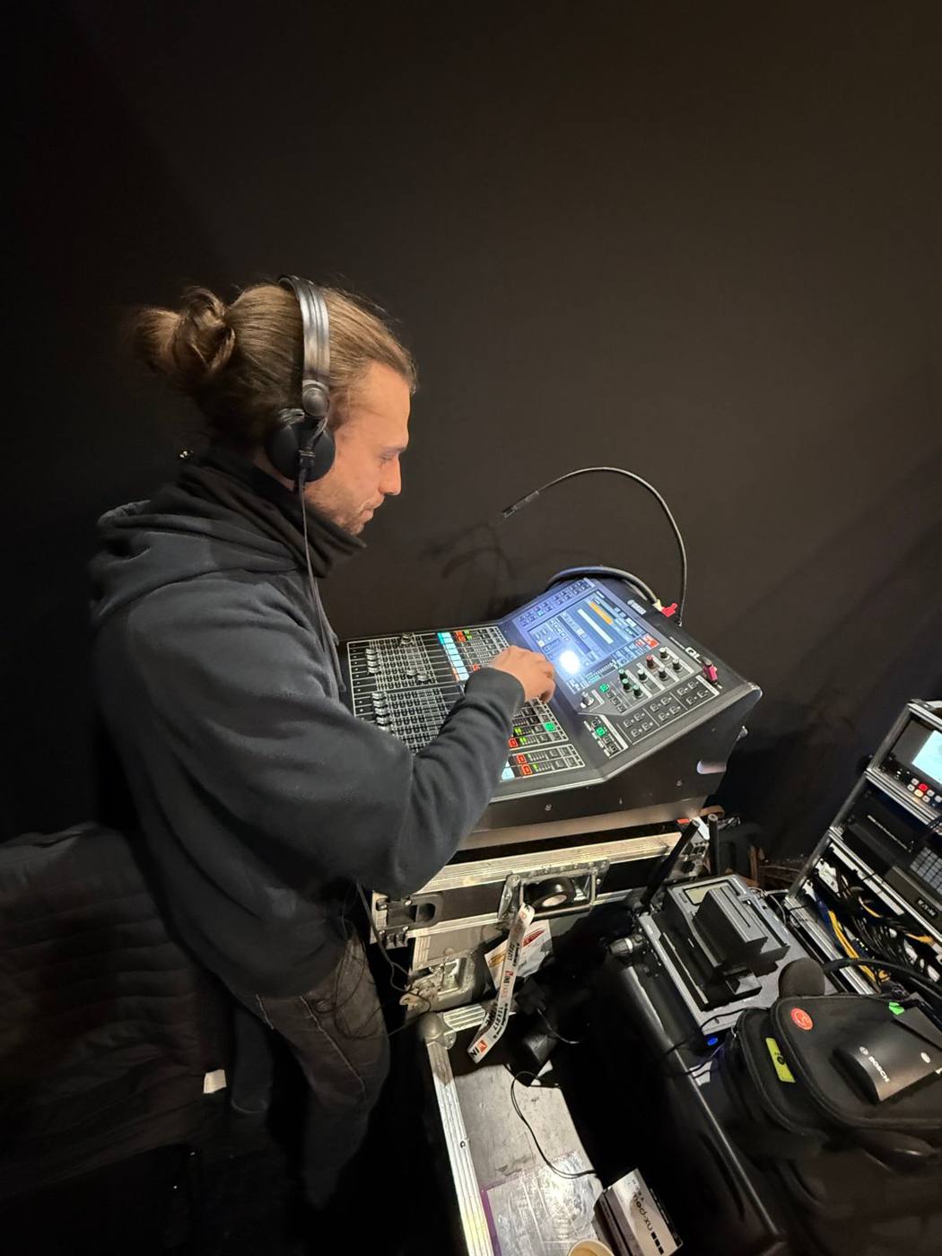 Ingénieur du son à la console Yamaha, casque sur les oreilles.